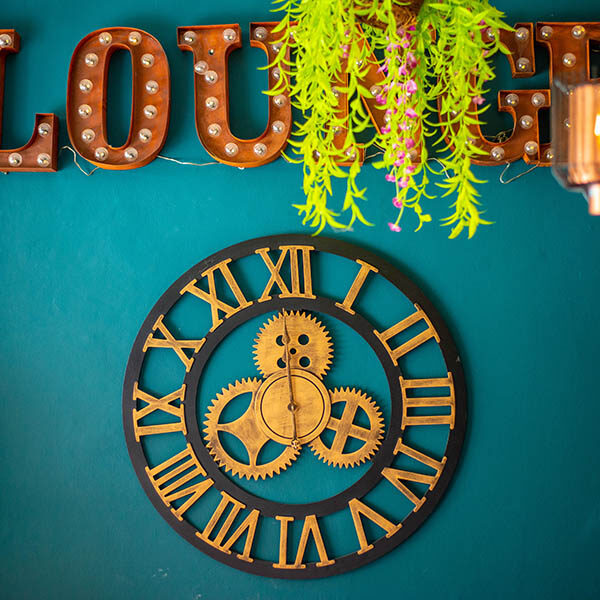 Close up of a large wall clock with "Lounge" sign above.