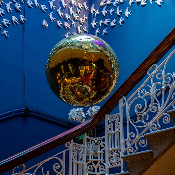 Large golden disco ball hanging in stairway