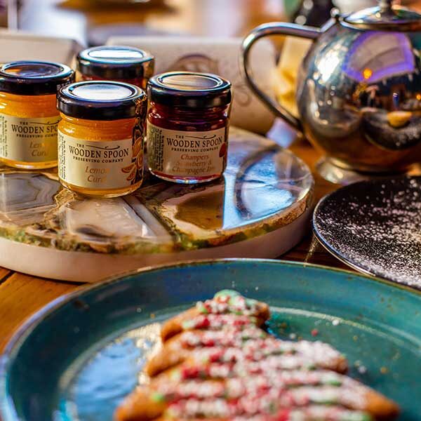 Close up of jams and lemon curd with a festive Christmas gingerbread in the foreground.