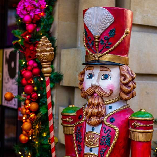 Close up image of a large colourful nutcracker at the entrance to Café Nucleus Rochester.